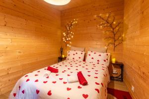 a bedroom with a bed with red hearts on it at Le Chalet Houda et spa en option in Nîmes