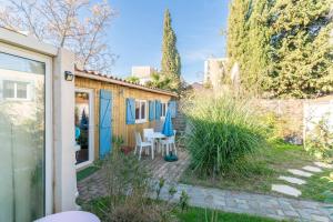 a small backyard with a table and chairs at Le Chalet Houda et spa en option in Nîmes