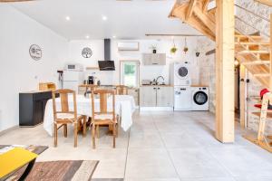 a kitchen and dining room with a table and chairs at Logement Le Buffet De La Gare in Falgueyrat