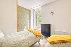 a bedroom with a bed and a window at Logement Le Buffet De La Gare in Falgueyrat