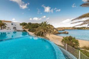 a swimming pool with a view of the beach at White Sands 4.20 in Arenal d'en Castell