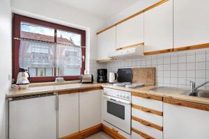 a kitchen with white cabinets and a window at Ferienpark Gustow B09 in Gustow