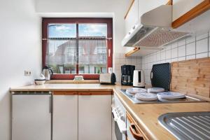a kitchen with white cabinets and a sink and a window at Ferienpark Gustow B09 in Gustow +13 photos