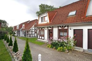 a row of white houses with red roofs at Ferienpark Gustow B09 in Gustow