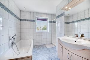 a white bathroom with a tub and a sink at Haus Reichl in Berndorf bei Salzburg