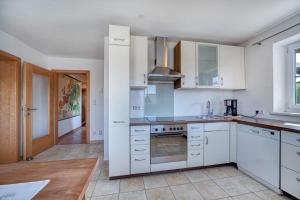 a kitchen with white cabinets and a stove top oven at Haus Reichl in Berndorf bei Salzburg