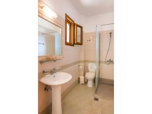 a bathroom with a sink and a toilet and a mirror at Petra Studios in Karpathos +46 photos