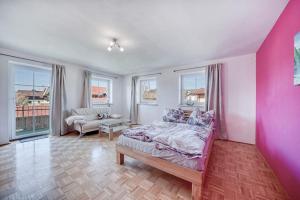 a bedroom with a bed and a pink wall at Haus Reichl in Berndorf bei Salzburg