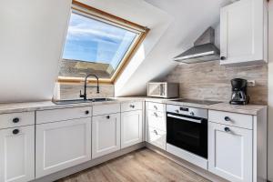 a kitchen with white cabinets and a window at Ferienwohnung Moritz in Lahr