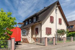 a house with a red trailer in front of it at Ferienwohnung Moritz in Lahr