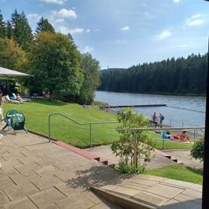 a park with people sitting on the grass near a lake at Ferienhaus Hahnenklee in Goslar