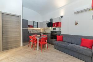a living room with a couch and a table and chairs at Rifla Vacanze in La Maddalena