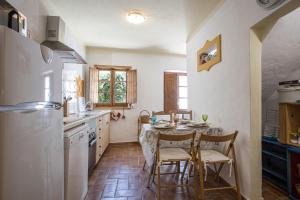 a kitchen with a table and chairs and a refrigerator at Casa Milita in Tavira
