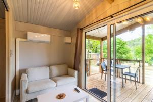 a living room with a couch and a table at Chalet Franklin 2 personnes in Saint-Martial-de-Nabirat