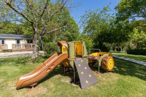 a playground with a slide in the grass at Chalet Franklin 2 personnes in Saint-Martial-de-Nabirat