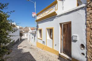 a building with a door on the side of a street at Casa Milita in Tavira
