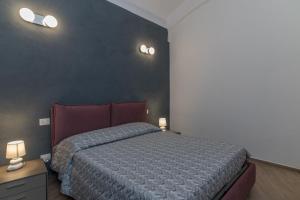 a bedroom with a bed and two lights on the wall at Rifla Vacanze in La Maddalena