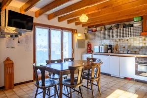 a kitchen with a wooden table and some chairs at Les Chalets Du Pres D'amont in Vagney +18 photos