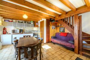 a kitchen and dining room with a table and a couch at Les Chalets Du Pres D'amont in Vagney
