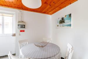 a white dining room with a table and chairs at Casa da Praya in Horta
