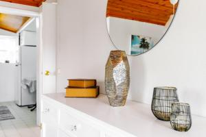 a room with a mirror and vases on a counter at Casa da Praya in Horta +23 photos