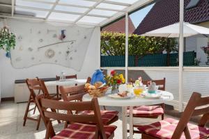 a patio with a table and chairs and an umbrella at Ferienbungalows Werner in Koserow