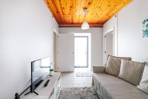 a living room with a couch and a tv at Casa da Praya in Horta