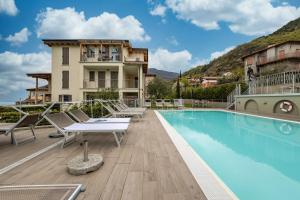 a hotel with a swimming pool and a building at Residence La Villa Tesoro in Tignale