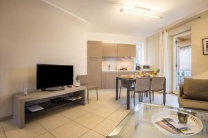 a living room with a television and a table at Residence La Villa Tesoro in Tignale