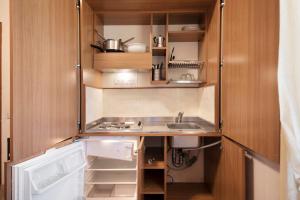 a small kitchen with wooden cabinets and a sink at Appartamento Bilocale Moneglia 37 in Moneglia