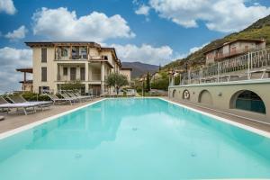 a large swimming pool in front of a building at Residence La Villa Tesoro in Tignale