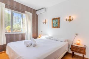 a bedroom with a white bed and a window at Casa Sillero Dos in Moraira +24 photos