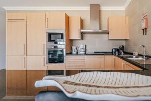 a kitchen with wooden cabinets and a couch in it at Beachfront Atlantic Sunset A07 in Óbidos