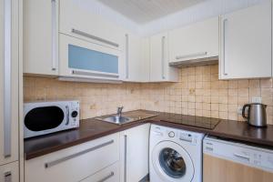 a kitchen with white cabinets and a sink and a microwave at Maison Centre Cannes Avec Terrasse in Cannes +11 photos