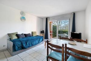 a living room with a bed and a dining room table at Appartement Du Golf - Pornic 1 in Pornic