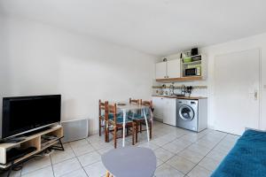 a living room with a table and a kitchen at Appartement Du Golf - Pornic 1 in Pornic +12 photos