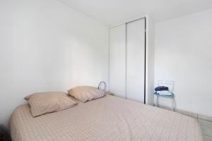 a bedroom with a bed with two pillows on it at Appartement Du Golf - Pornic 1 in Pornic
