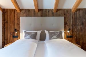 a bedroom with two white beds and wooden walls at Moarhof Ums in Umes