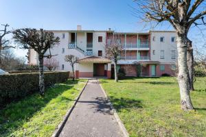 a walkway in front of a large building at Appartement Du Golf - Pornic 1 in Pornic