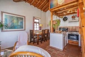 a kitchen and dining room with a table and chairs at Casa da Praia 1 in Budens