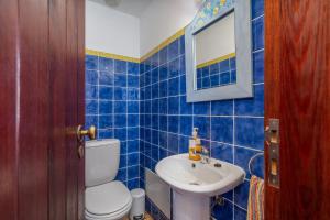 a blue tiled bathroom with a toilet and a sink at Casa da Praia 1 in Budens +17 photos
