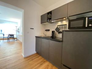 a kitchen with stainless steel appliances and a wooden floor at Myzell in Radolfzell am Bodensee +3 photos