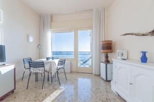 a dining room with a table and chairs and a window at La finestra sul mare in Ospedaletti