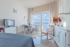 a bedroom with a bed and a table and chairs at La finestra sul mare in Ospedaletti