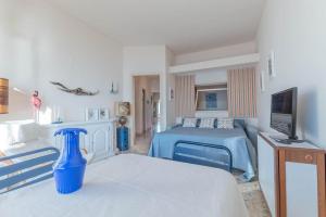 a bedroom with two beds and a blue vase at La finestra sul mare in Ospedaletti
