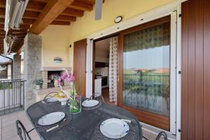a dining table on a balcony with a sliding glass door at Residence Bardolino in Bardolino