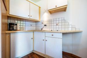 a kitchen with white cabinets and a sink at Talblick Apartement 1 in Laion