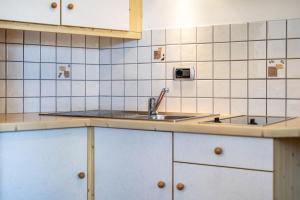a kitchen with white cabinets and a sink at Talblick Apartement 1 in Laion