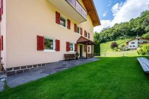 a house with red shutters and a green lawn at Talblick Apartement 1 in Laion +11 photos