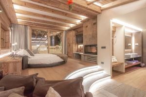 a bedroom with a bed and a living room at Le Chalet Suite Livigno in Livigno